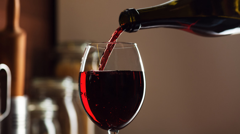 close up pouring red wine into glass