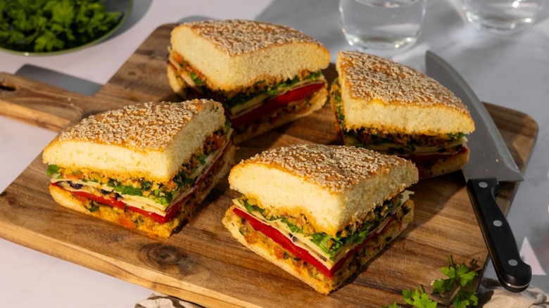 Sliced eggplant muffuletta sandwich on wooden board