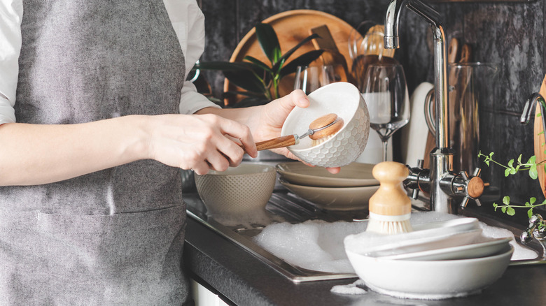 Person washing dishes at sink