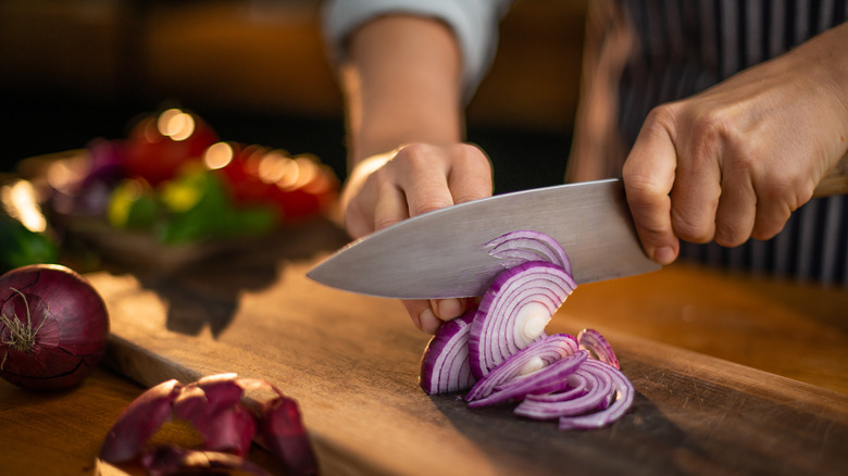 Slicing red onion on counter