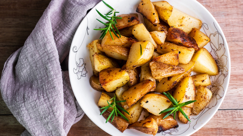 plate of roasted potatoes garnished with rosemary