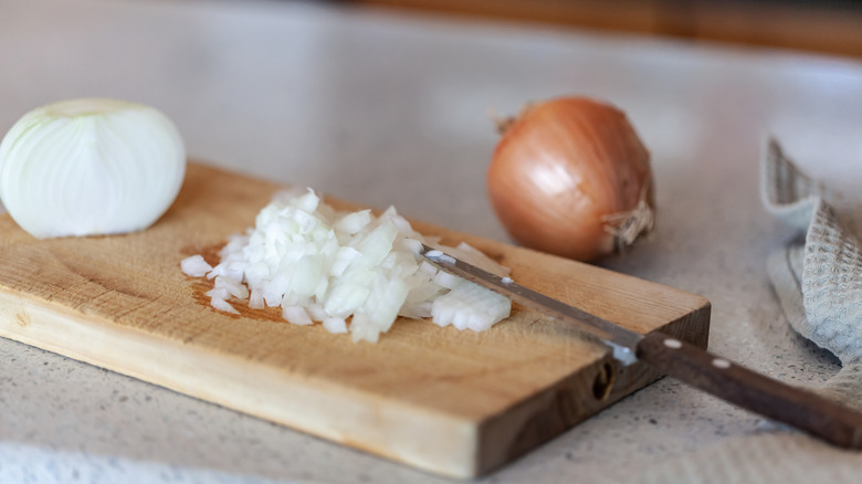 chopped up onion on wooden cutting board