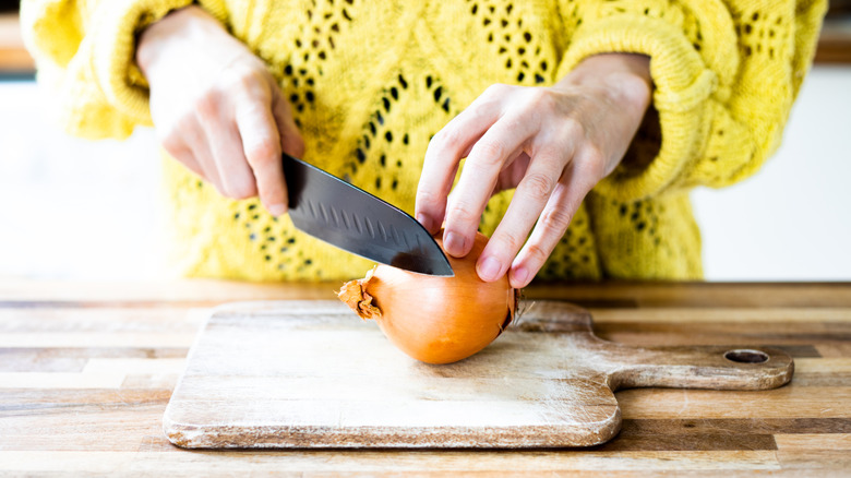 Person about to cut an onion with a knife