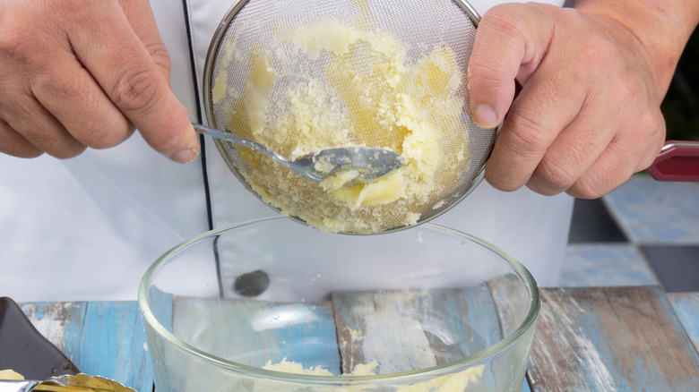 potatoes in a sieve with hands