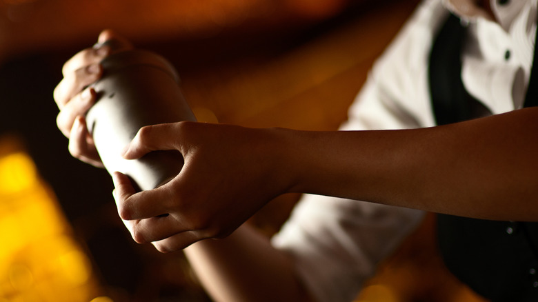 Hands holding a cocktail shaker