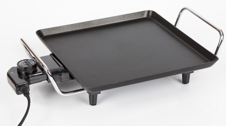 An electric griddle for cooking on a white background