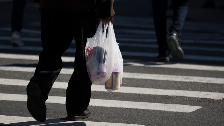 shopper carrying groceries in plastic bags