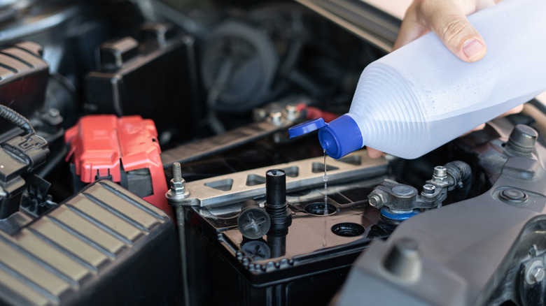 Distilled water being poured into an engine