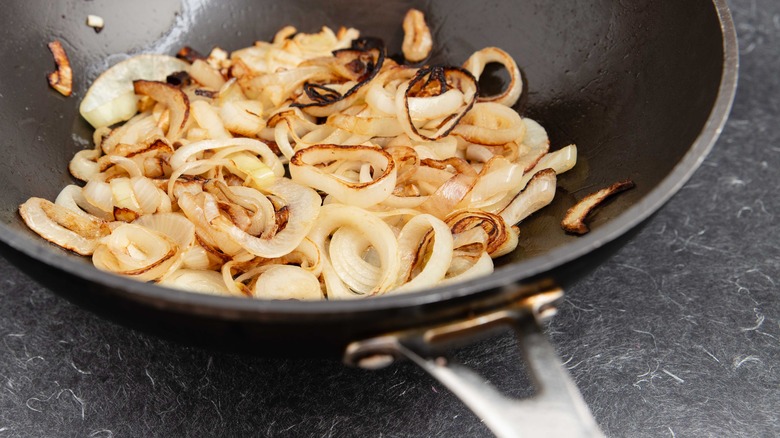 sliced onions caramelizing in pan