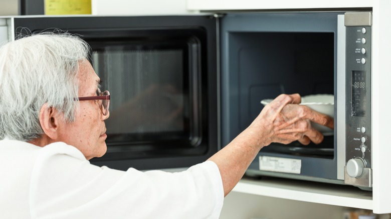 Person removes bowl from microwave