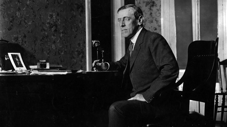 Black and white photo of President Woodrow Wilson seated at desk