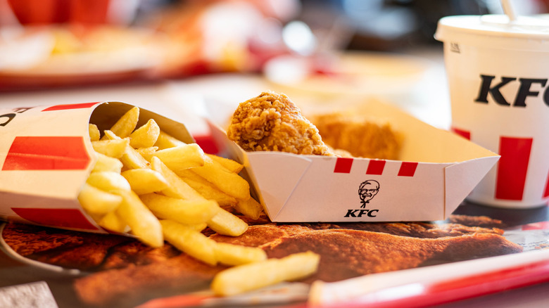 KFC fried chicken, fries, and a drink on a tray
