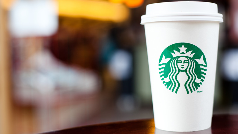 A Starbucks cup against a blurred background.