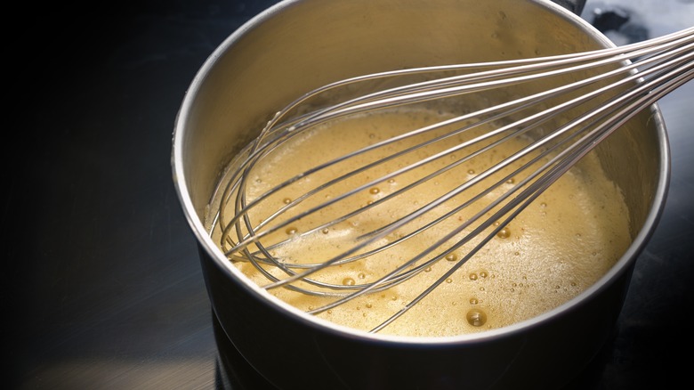 whisking pot of hollandaise sauce