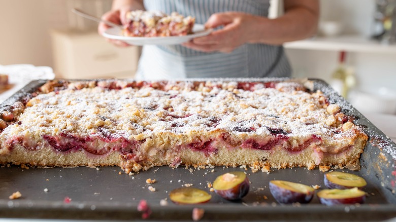 Home baker slicing up a homemade sheet cake