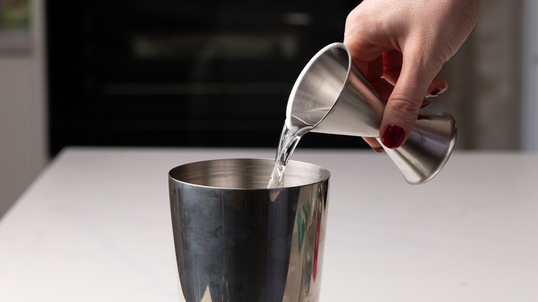 pouring gin into cocktail shaker