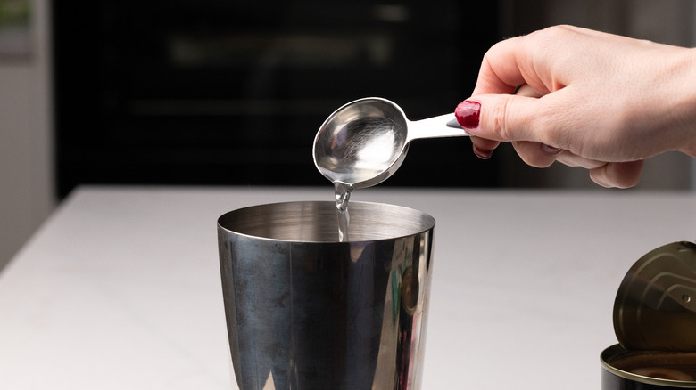 pouring lychee syrup into shaker