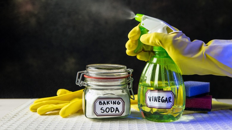 Person cleaning with white vinegar and baking soda