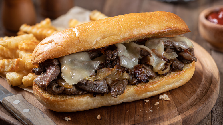 cheesesteak on wood with fries