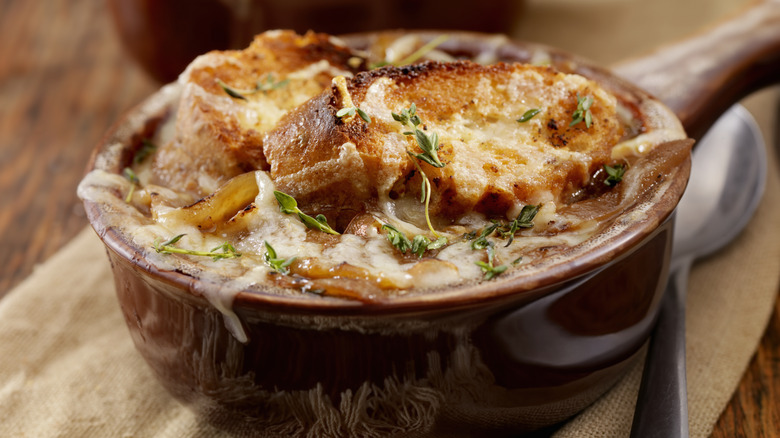 crock of French onion soup with spoon