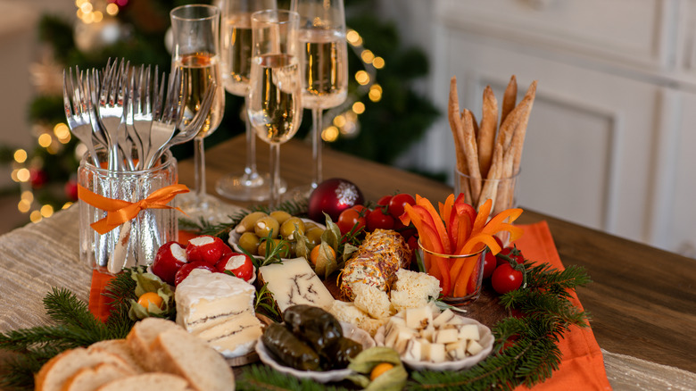 Table with sparkling wine glasses, olives, cheeses, bread