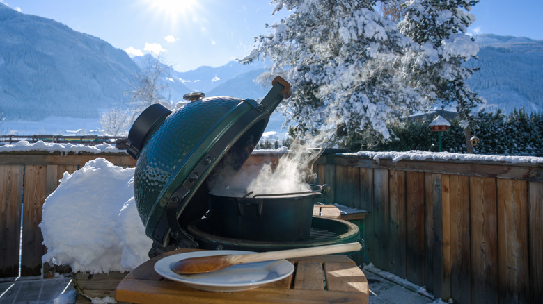 An open Green Egg grill on a snowy patio