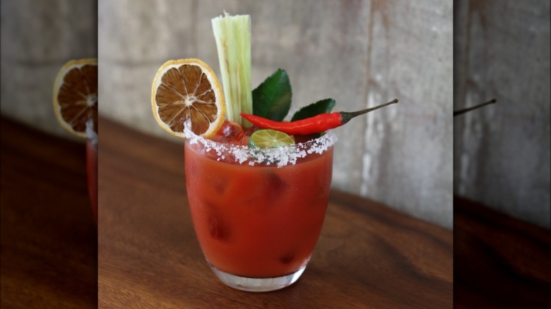 bloody mary garnished with chili, dried orange, and lemongrass