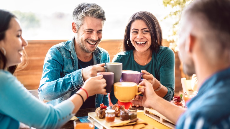 friends toasting with coffee mugs