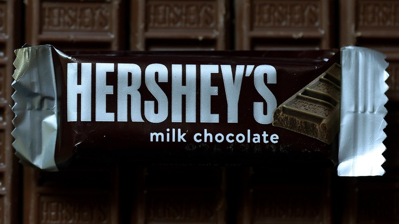 A wrapped Hershey's Milk Chocolate Bar on top of chocolate bars