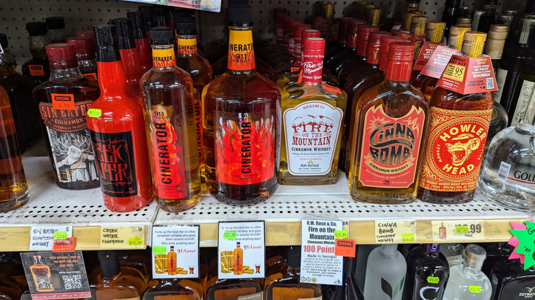 Cinnamon whiskey bottles on shelves.