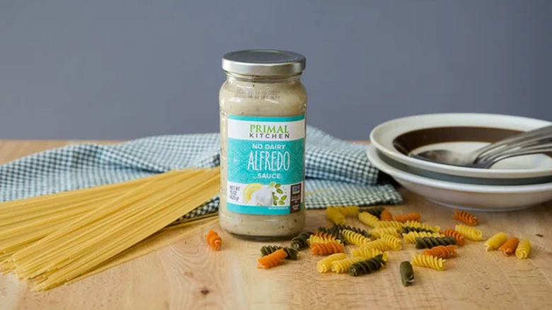 A jar of Primal Kitchen No Dairy Alfredo Sauce with dried pastas
