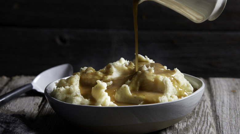 A person pouring gravy.