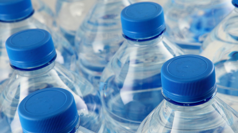 Close-up of the tops of several plastic bottles of water