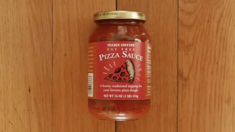 Trader Joe's pizza sauce lies on a wooden counter