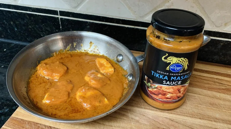 chicken tikka masala next to a bottle of tikka masala sauce
