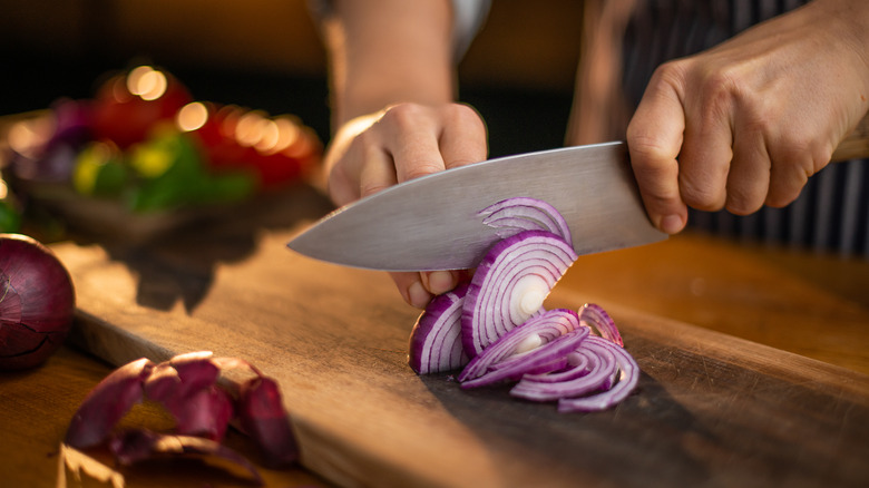 slicing onion on cutting board