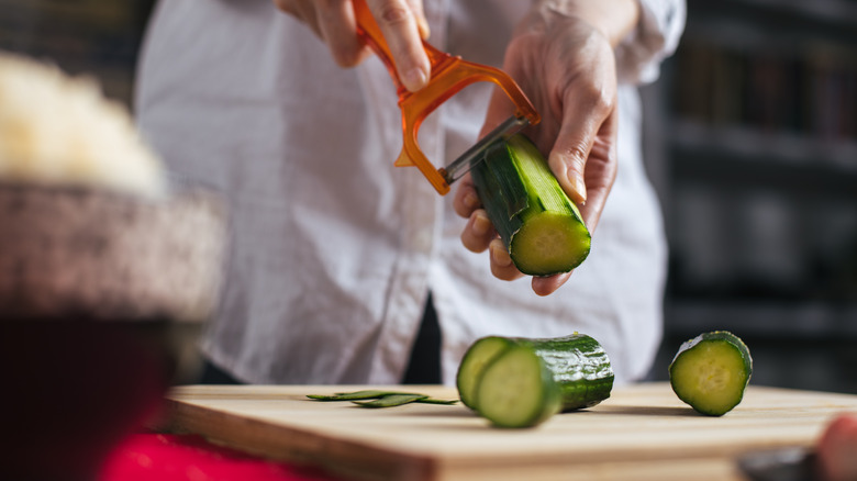 person peeling cucumbers