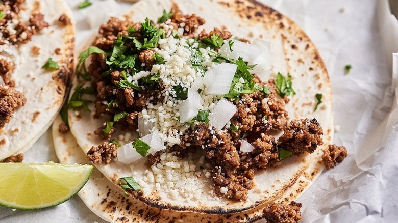 Tacos with ground beef, cotija cheese, and cilantro