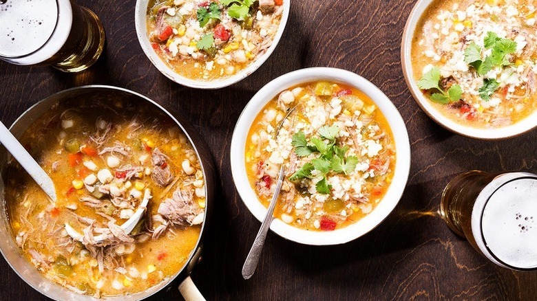 Pork pozole in pot and servings bowls