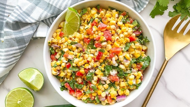 Bowl of Mexican street corn salad with lime