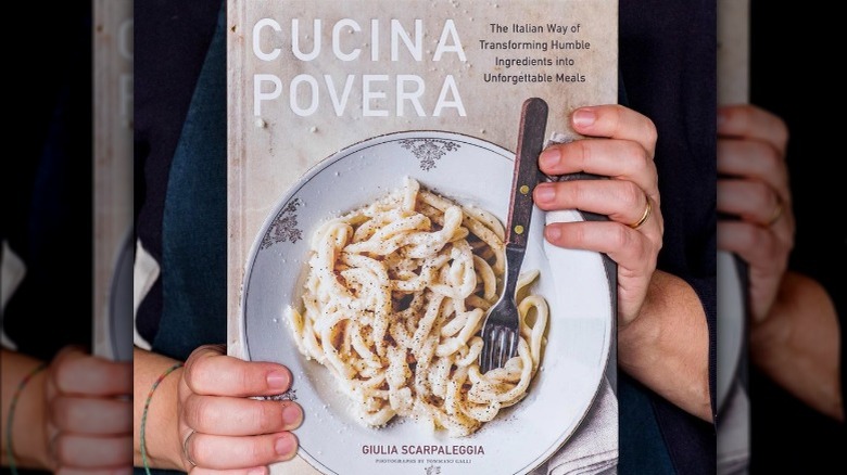 Woman holding Cucina Povera cookbook