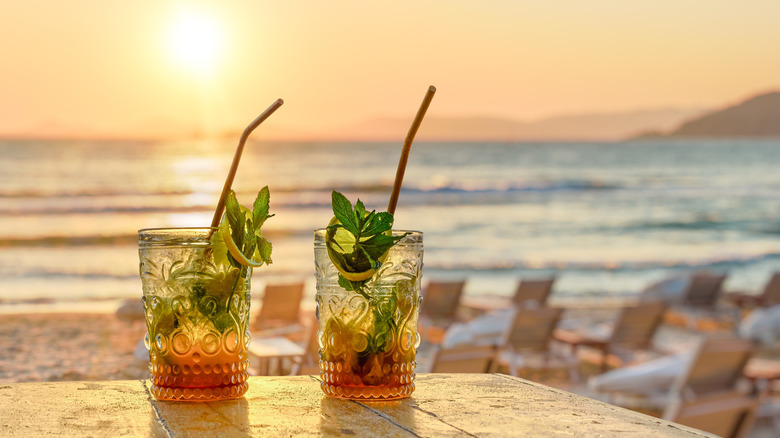 Two drinks with straws and an ocean background