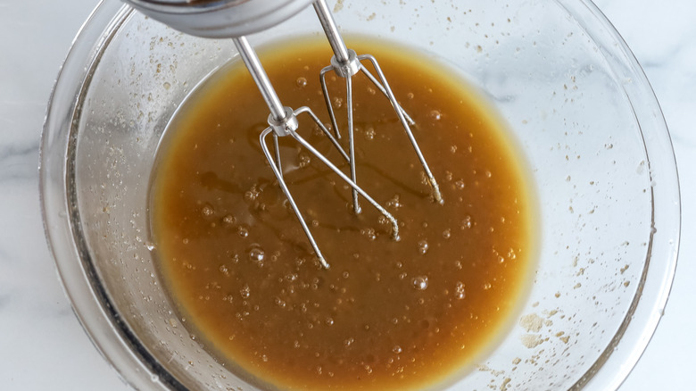 beating melted butter with sugars