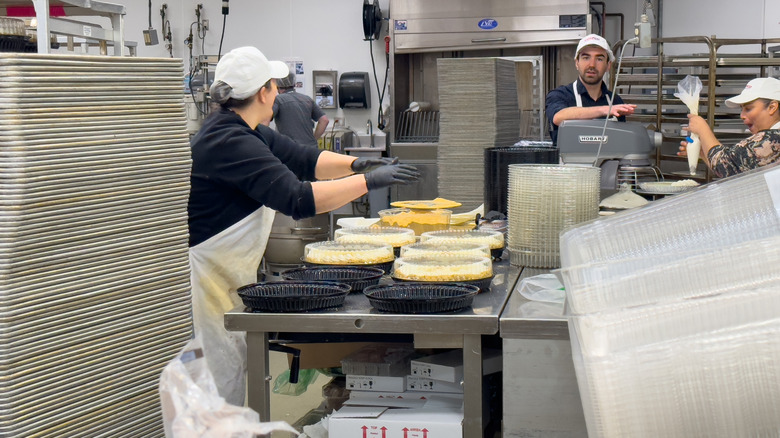 busy Costco bakery bakers filling cake tins in kitchen