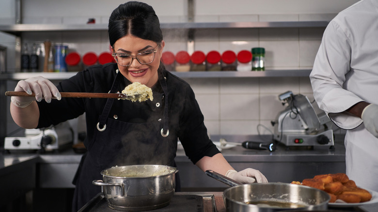 woman tasting mashed potatoes