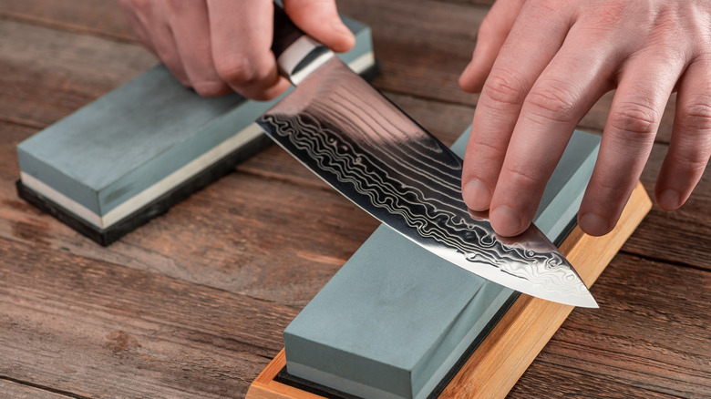 Knife being sharpened on a whetstone