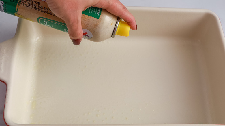 Baking pan being greased with nonstick spray