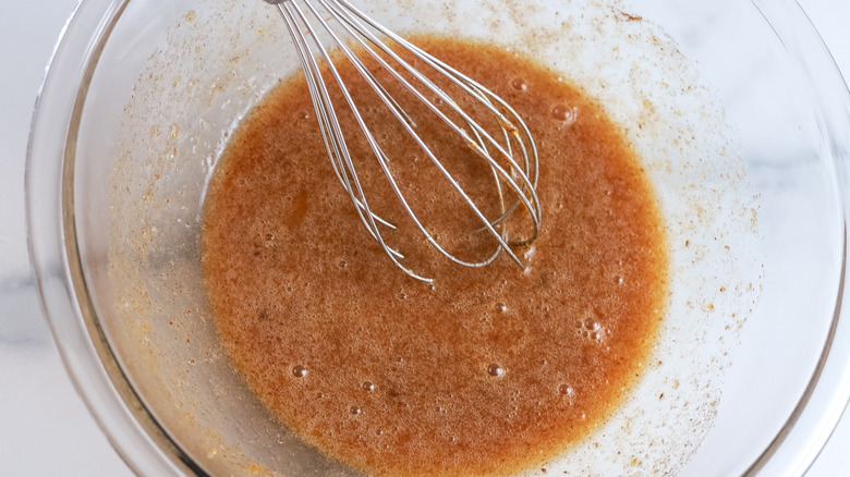 Wet ingredients mixed in a bowl with a whisk