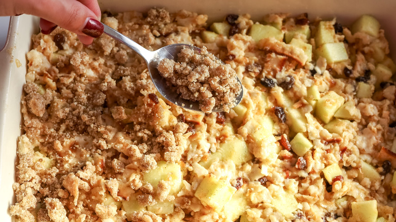 Streusel being sprinkled over an apple matzo kugel