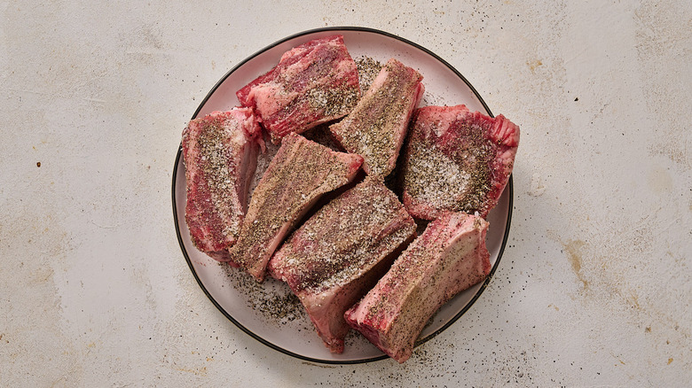 seasoning short ribs on a plate